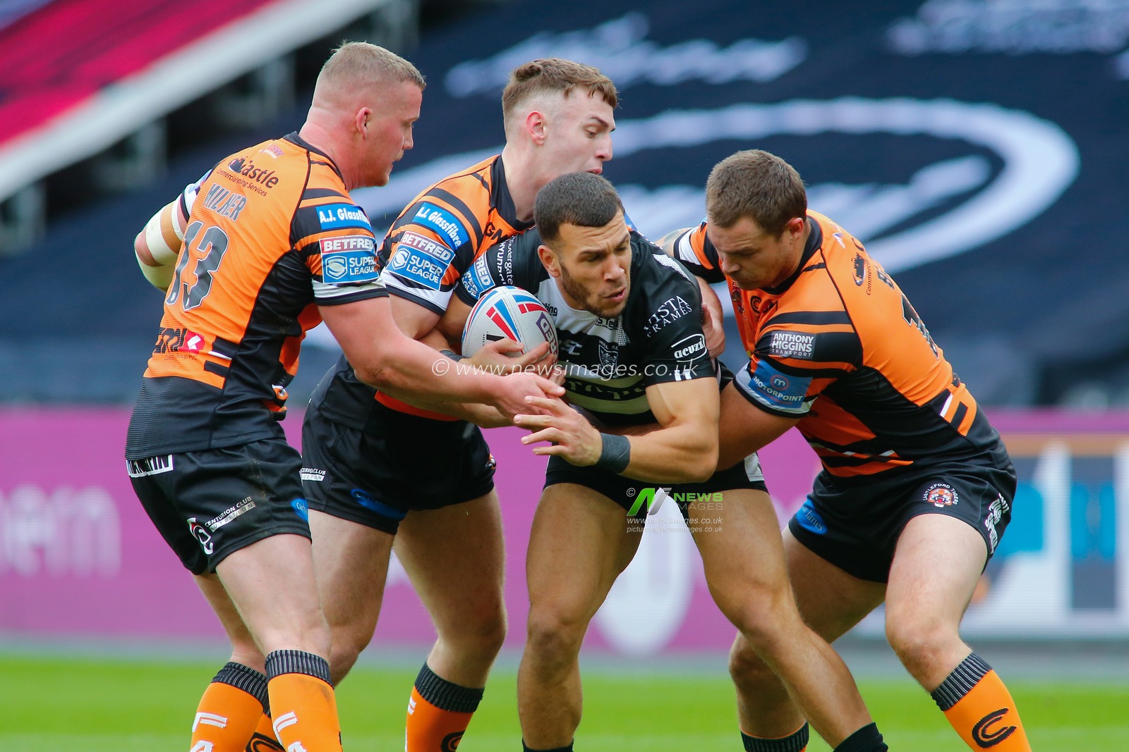 Carlos Tuimavave (3) of Hull FC tackled by Adam Milner (13) and Cheyse Blair (18) and Jake Trueman (6) of Castleford Tigers.