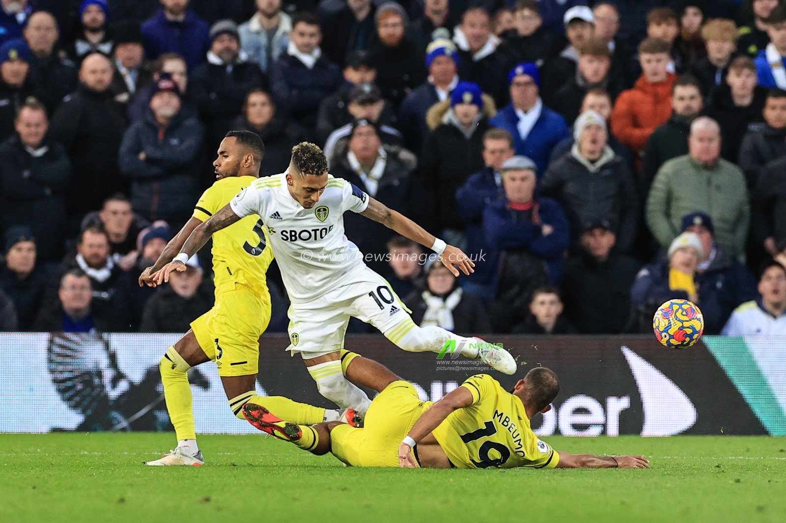 Raphinha #10 of Leeds United fouls Bryan Mbeumo #19 of Brentford