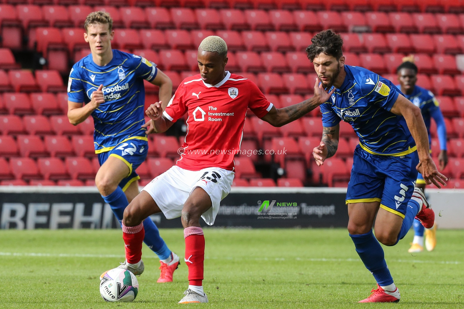 Elliot Simoes (23) of Barnsley shields the ball away from Tobias Figueiredo (3) of Nottingham Forest