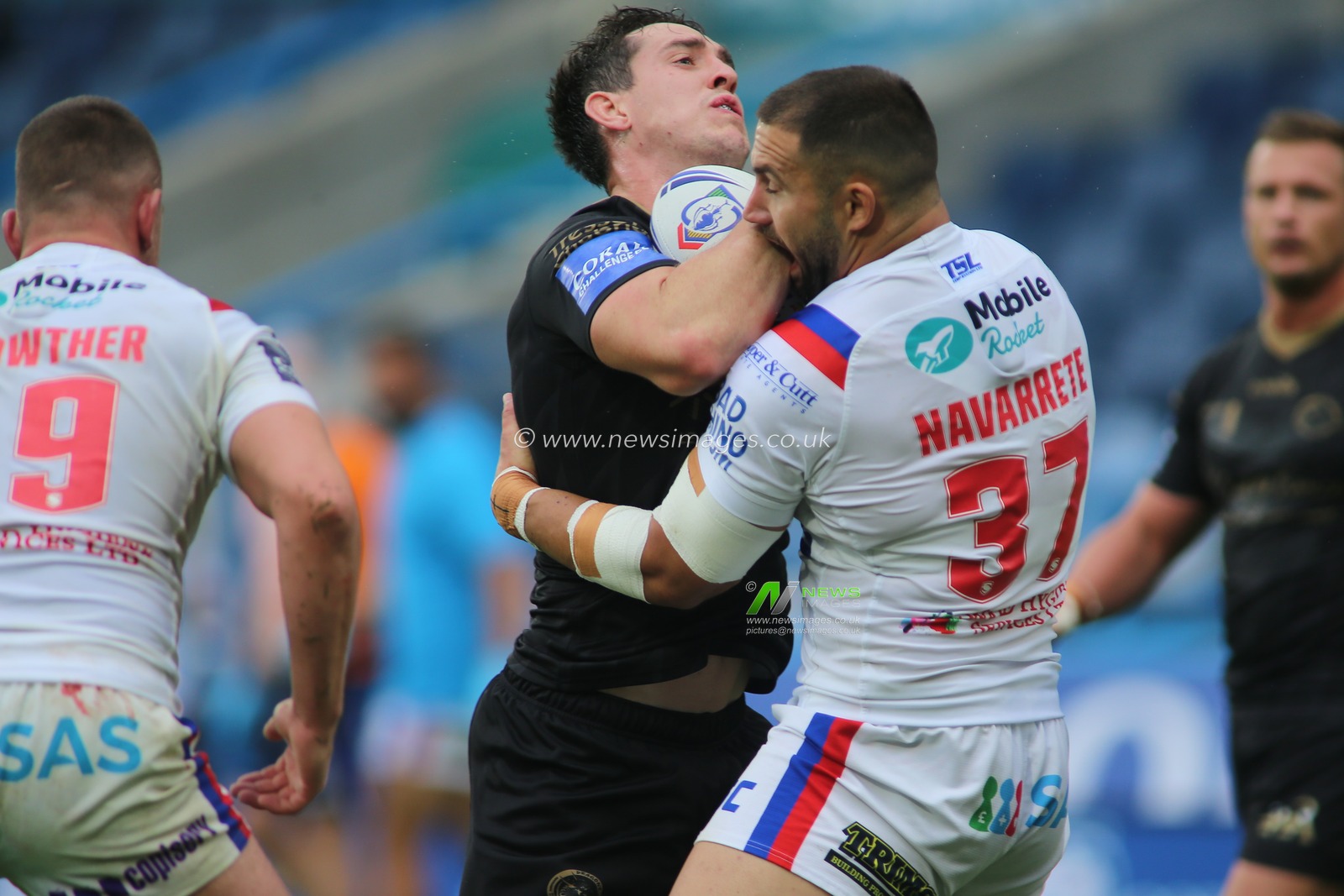 Matt Whitley (11) of Catalan Dragons runs in to Romain Navarrete (37) of Wakefield Trinity.