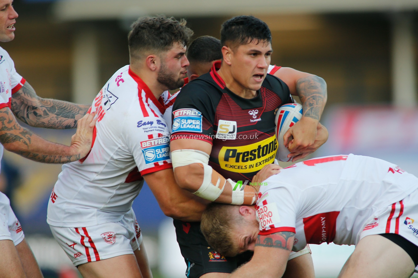 Mitch Clark (22) of Wigan Warriors tackled by a strong Hull KR defence.