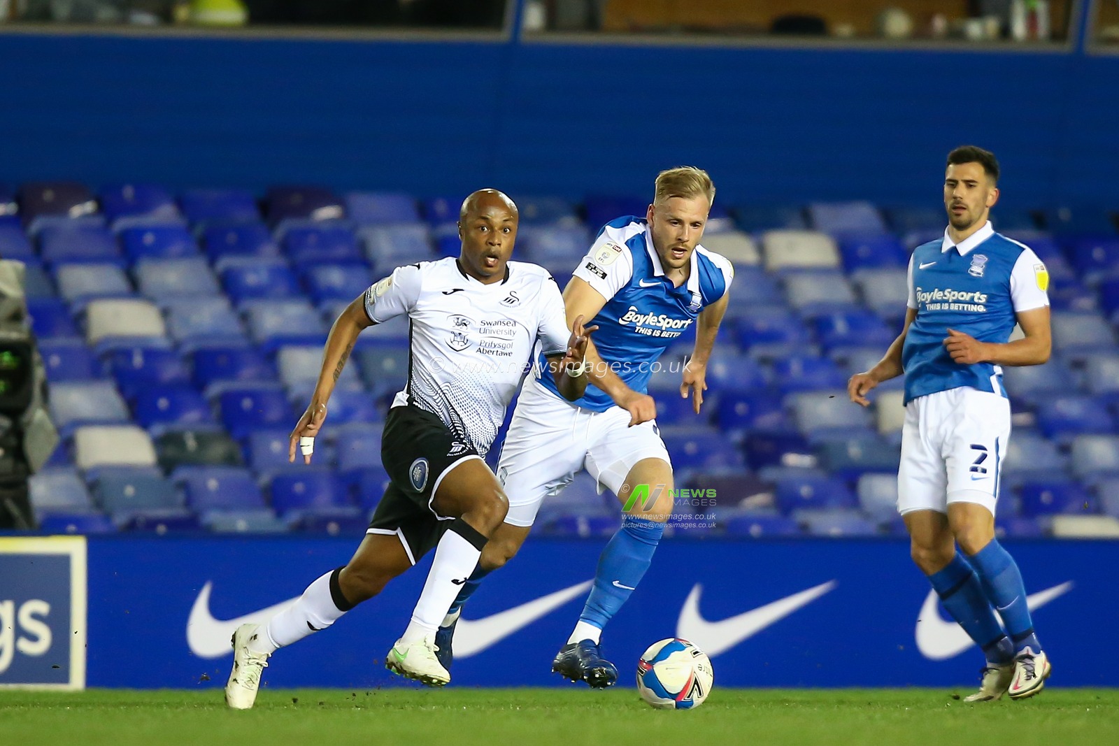 Andre Ayew #10 of Swansea City dribbles the ball whilst under pressure from Marc Roberts #4 of Birmingham City