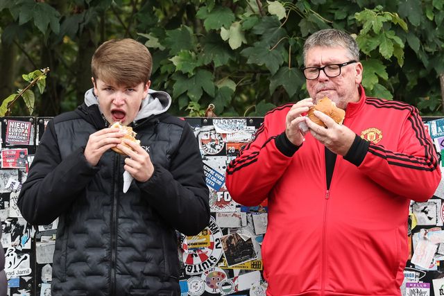 Two Manchester United fans grab a bite to eat during the Premier League match Manchester United vs Tottenham Hotspur at Old Trafford, Manchester, United Kingdom, 29th September 2024

(Photo by Mark Cosgrove/News Images)