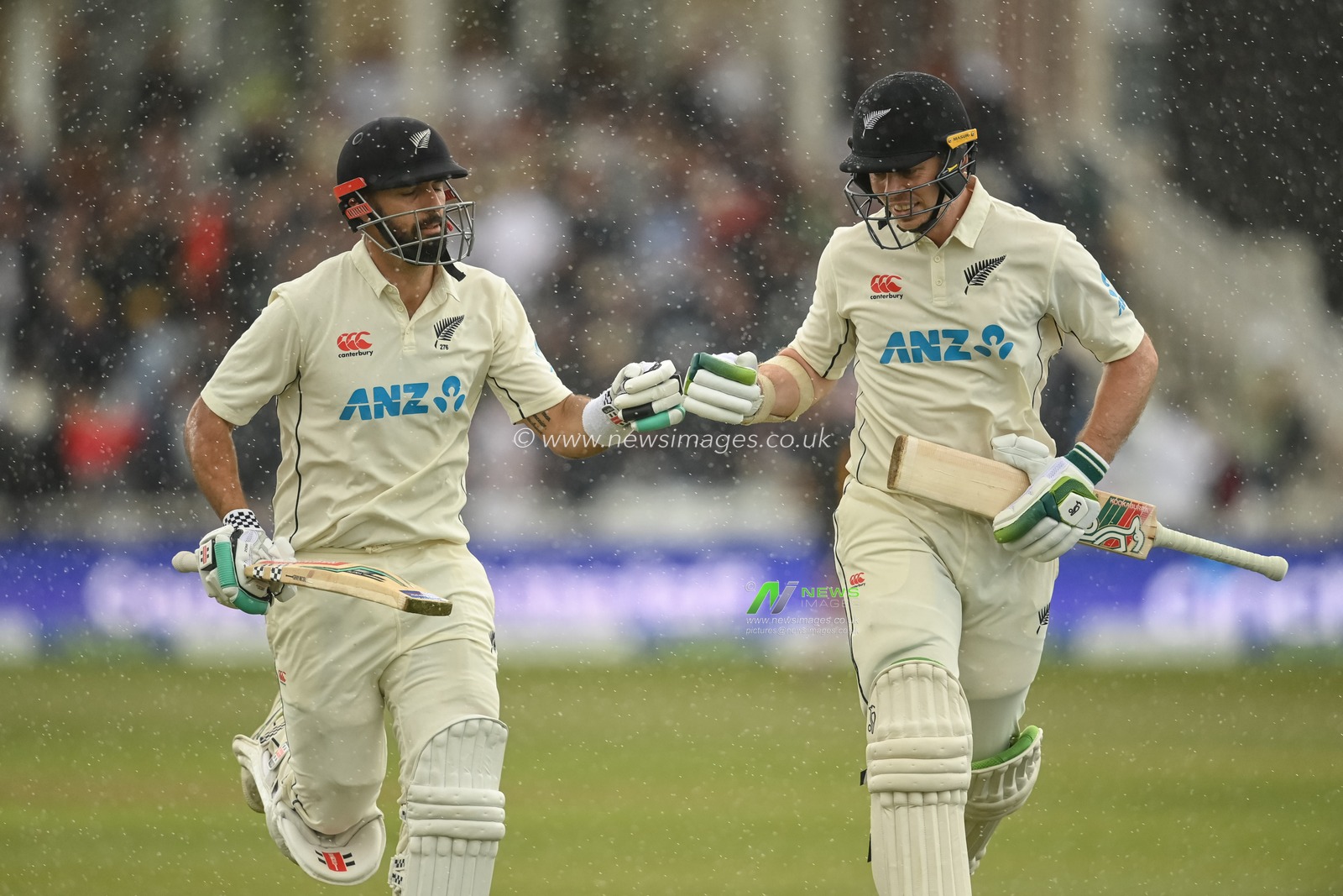 Daryl Mitchell of New Zealand (L) and Michael Bracewell of New Zealand (R) bump fists as they head in after rain stops play during day 2 of the 2nd Test between the New Zealand Blackcaps and England at Trent Bridge Cricket Ground, Nottingham, England on Saturday 11 June 2022.