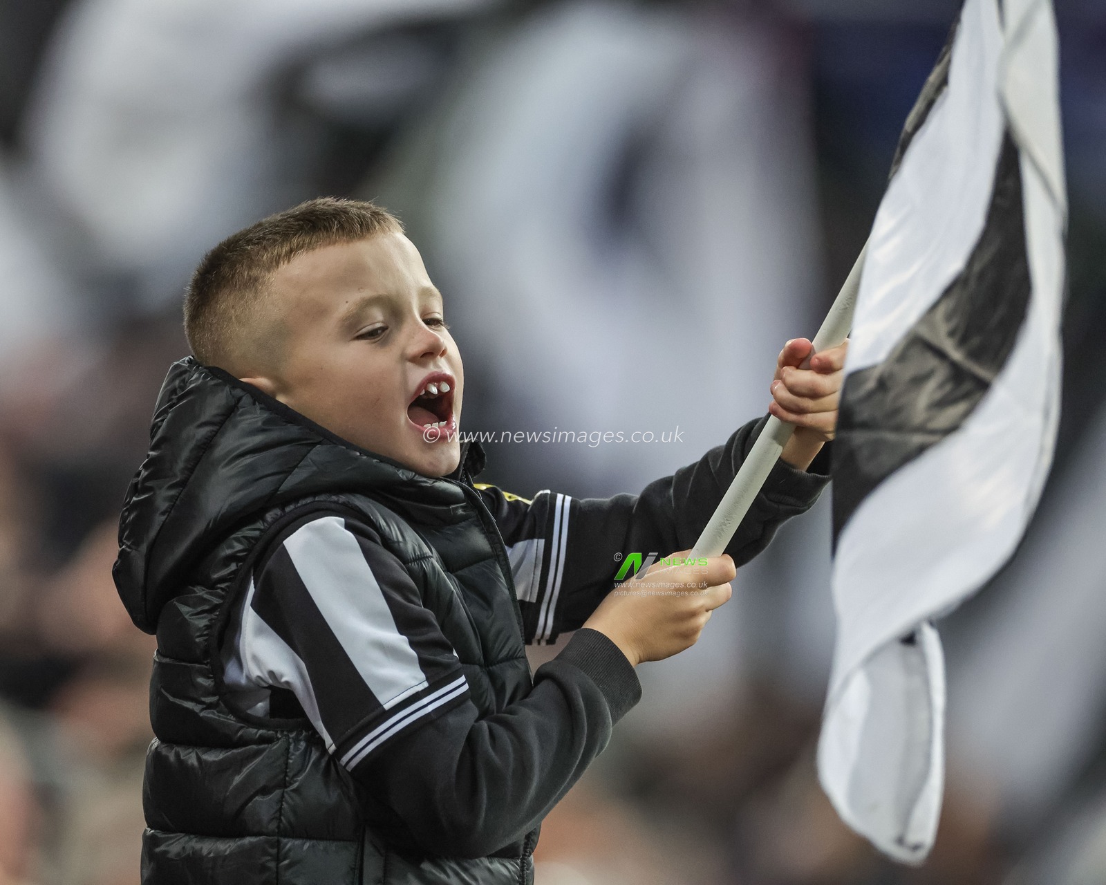 A young Newcastle fans sings and waves a flag during the Premier League match Newcastle United vs Arsenal at St. James's Park, Newcastle, United Kingdom, 4th November 2023

(Photo by Mark Cosgrove/News Images)