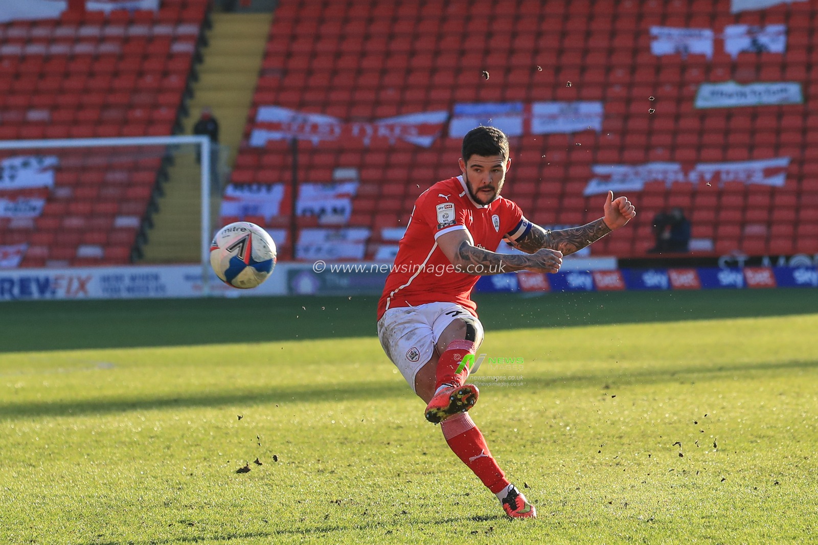 Alex Mowatt #27 of Barnsley forces Bartosz BiaÅ‚kowski #33 of Millwall to make a fingertip save from his free-kick