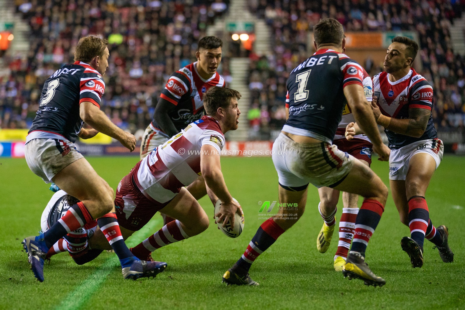 Wigan Warriors's Joe Greenwood is tackled by  Sydney Roosters Cooper Cronk


17th February  2019 , DW Stadium, Wigan, England;  Betfred World Club Challenge, Wigan Warriors vs Sydney Roosters ; 

Credit: Terry Donnelly/News Images