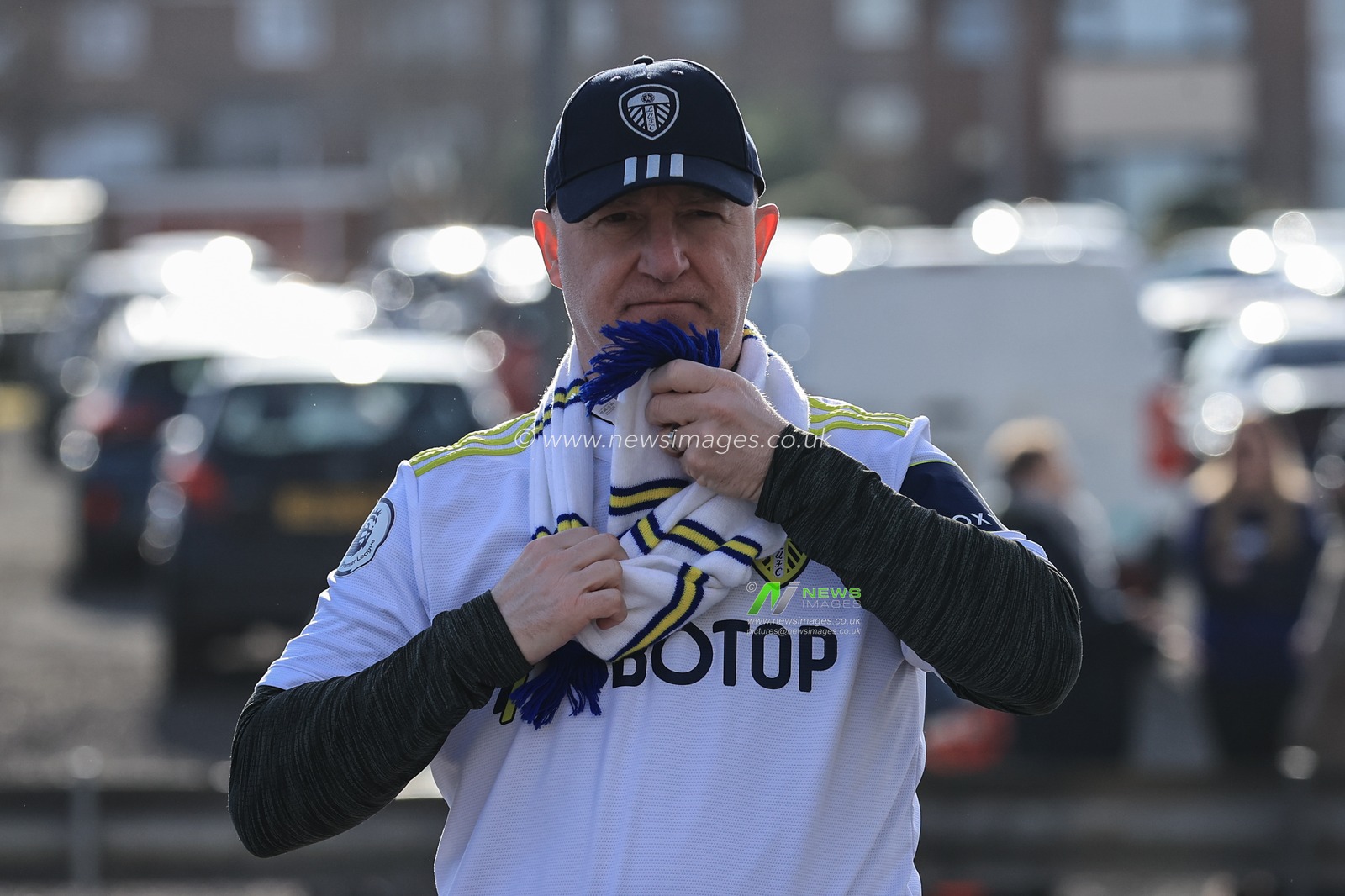 A Leeds fan ties his scarf