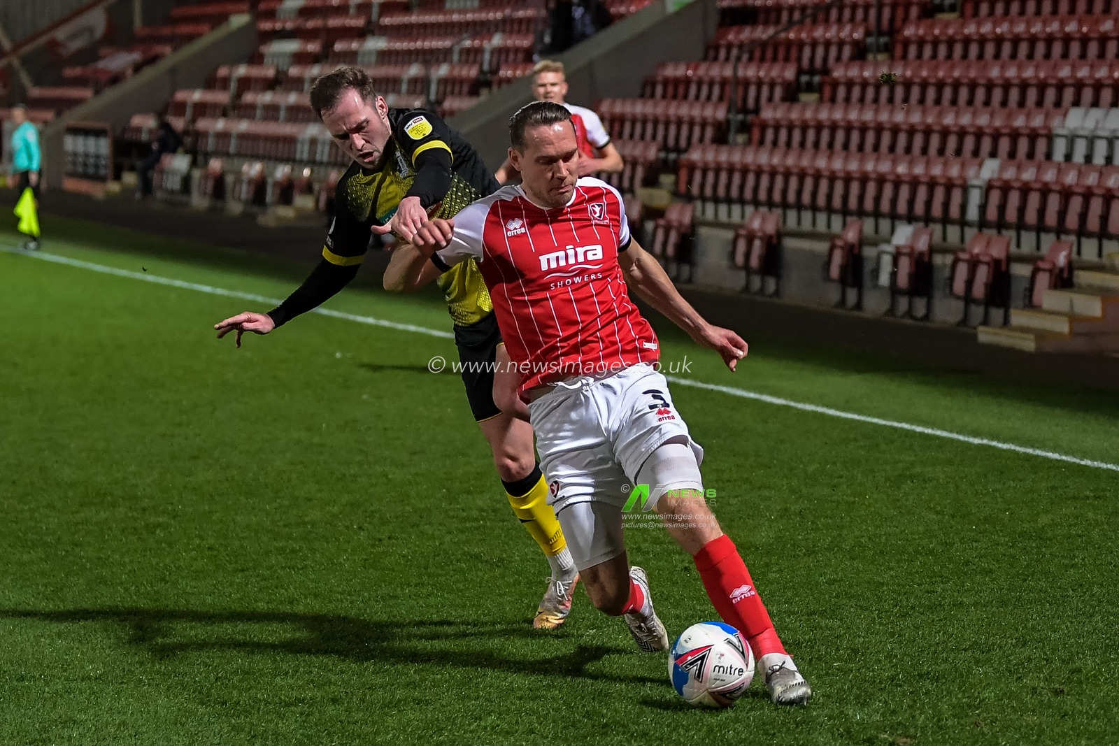 Chris Hussey #3 of Cheltenham Town gets past Josh Kay #11 of Barrow to get the cross into the area