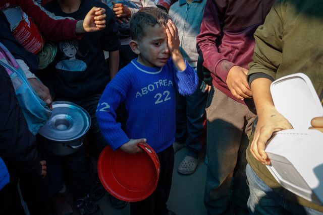 Palestinians try to get a free meal (from a charity restaurant) in a temporary displacement camp in Deir Al-Balah.