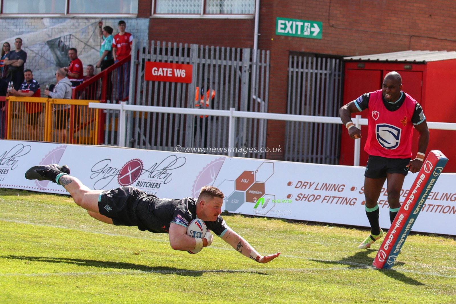 Luke Yates #13 of Huddersfield Giants dives in to score his try