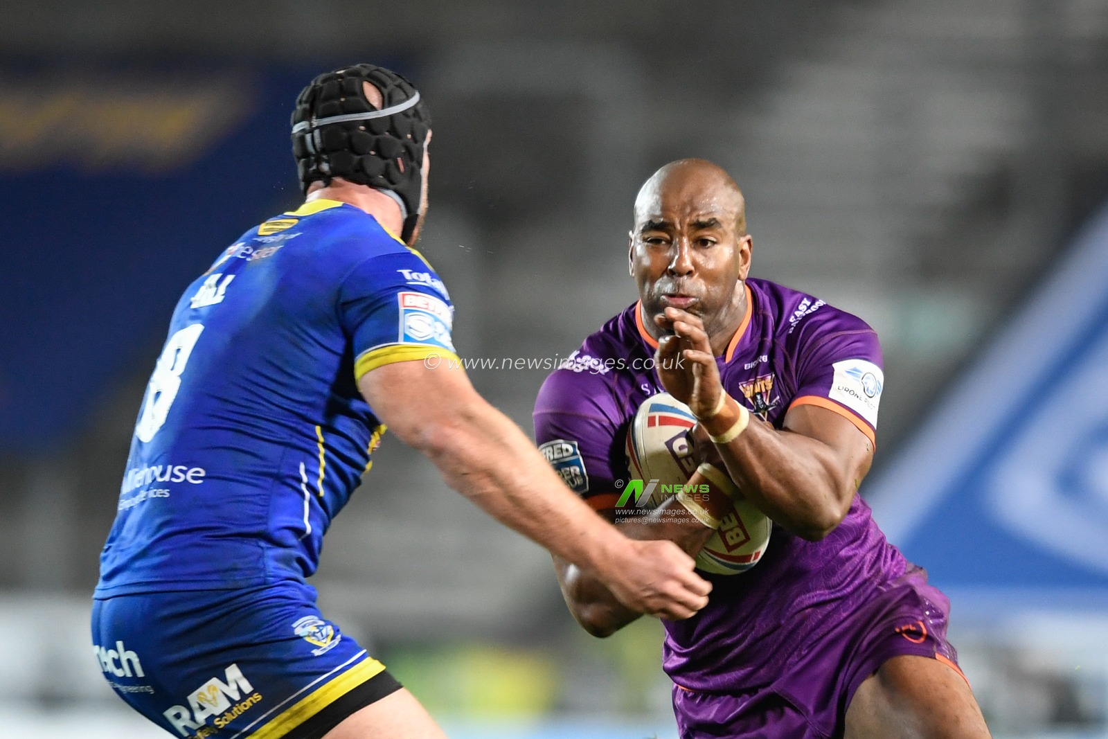 Michael Lawrence (13) of Huddersfield Giants attempts to get past Chris Hill (8) of Warrington Wolves