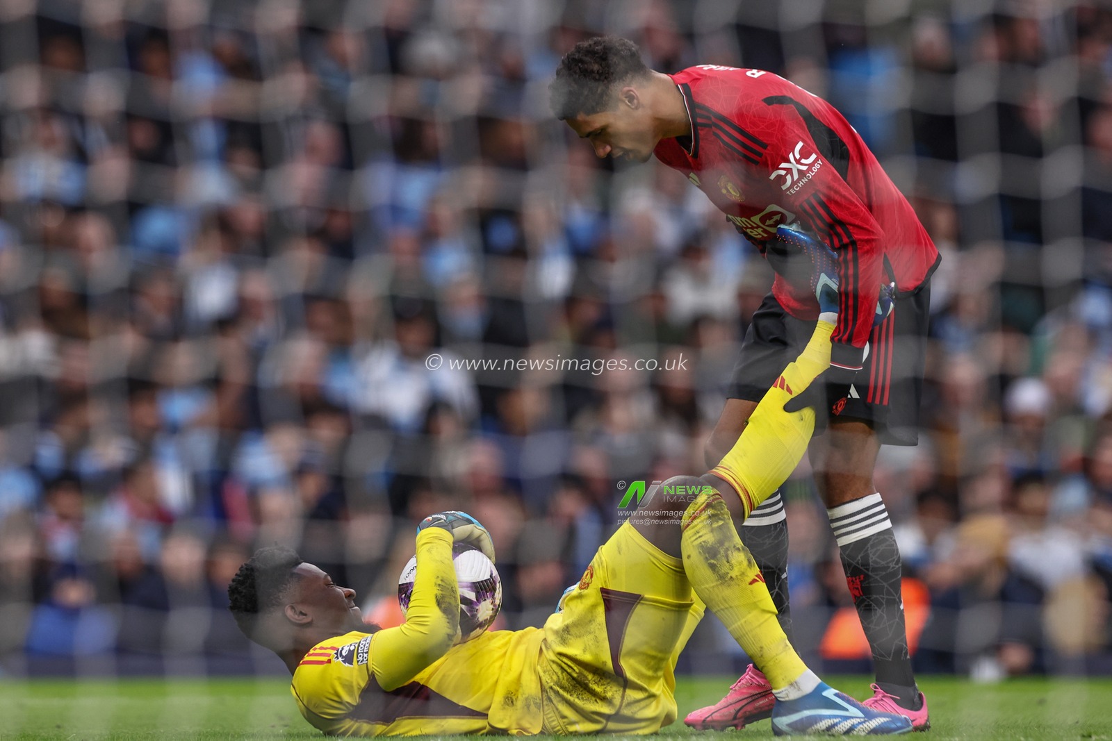 RaphaÃ«l Varane of Manchester United helps AndrÃ© Onana of Manchester United after he gets cramp in his leg during the Premier League match Manchester City vs Manchester United at Etihad Stadium, Manchester, United Kingdom, 3rd March 2024

(Photo by Mark Cosgrove/News Images)