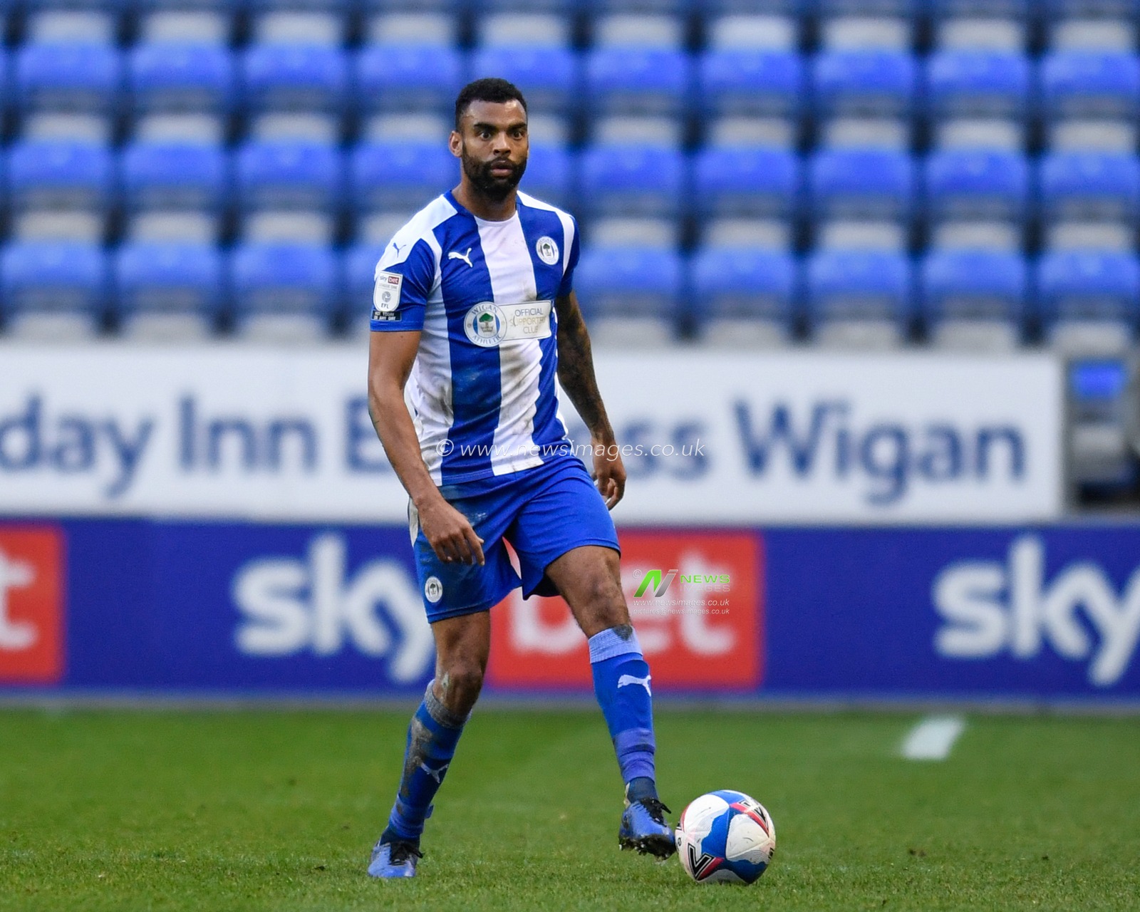 Curtis Tilt #4 of Wigan Athletic looks for a pass