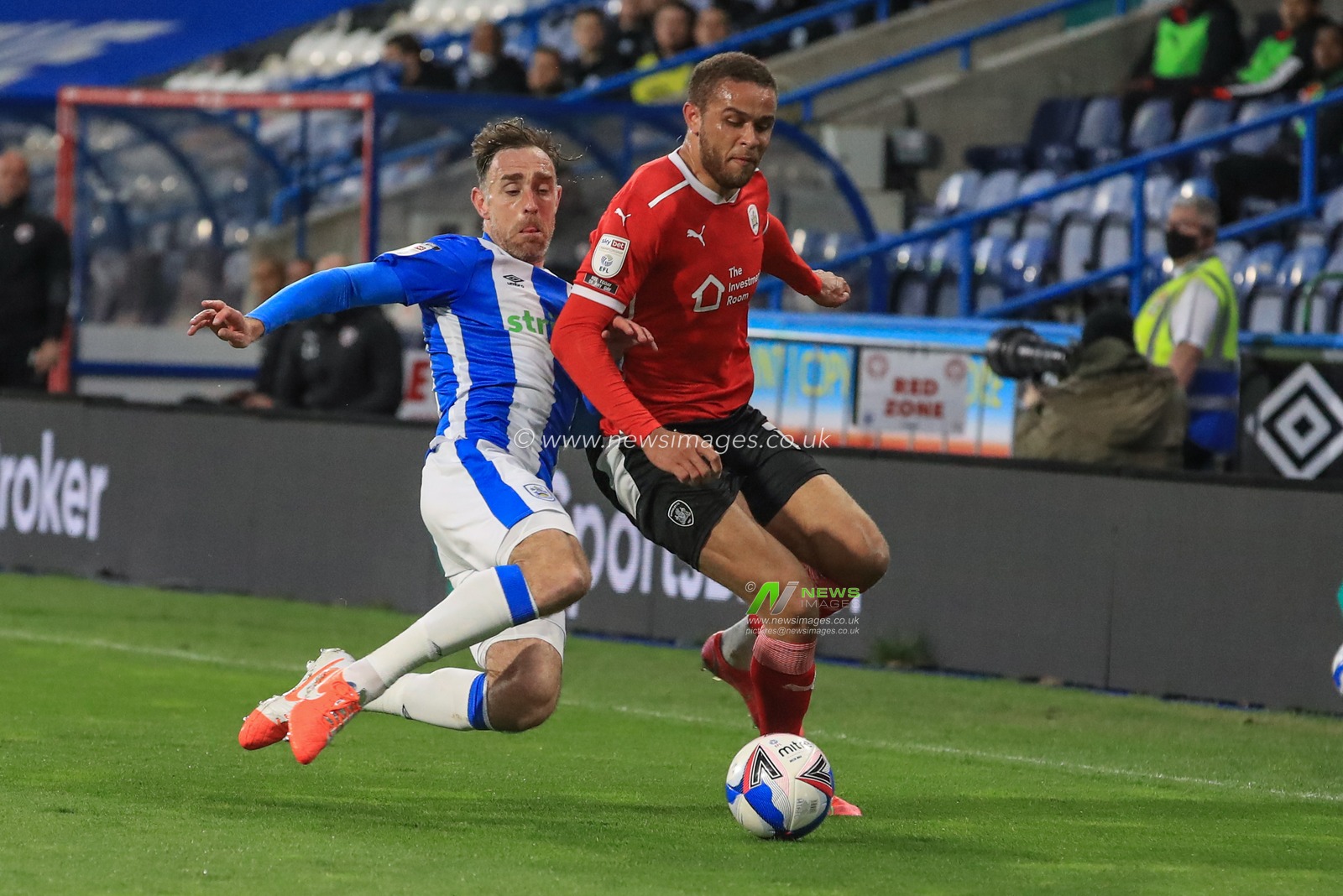 Richard Keogh #15 of Huddersfield Town slides in to win the ball from Carlton Morris #14 of Barnsley