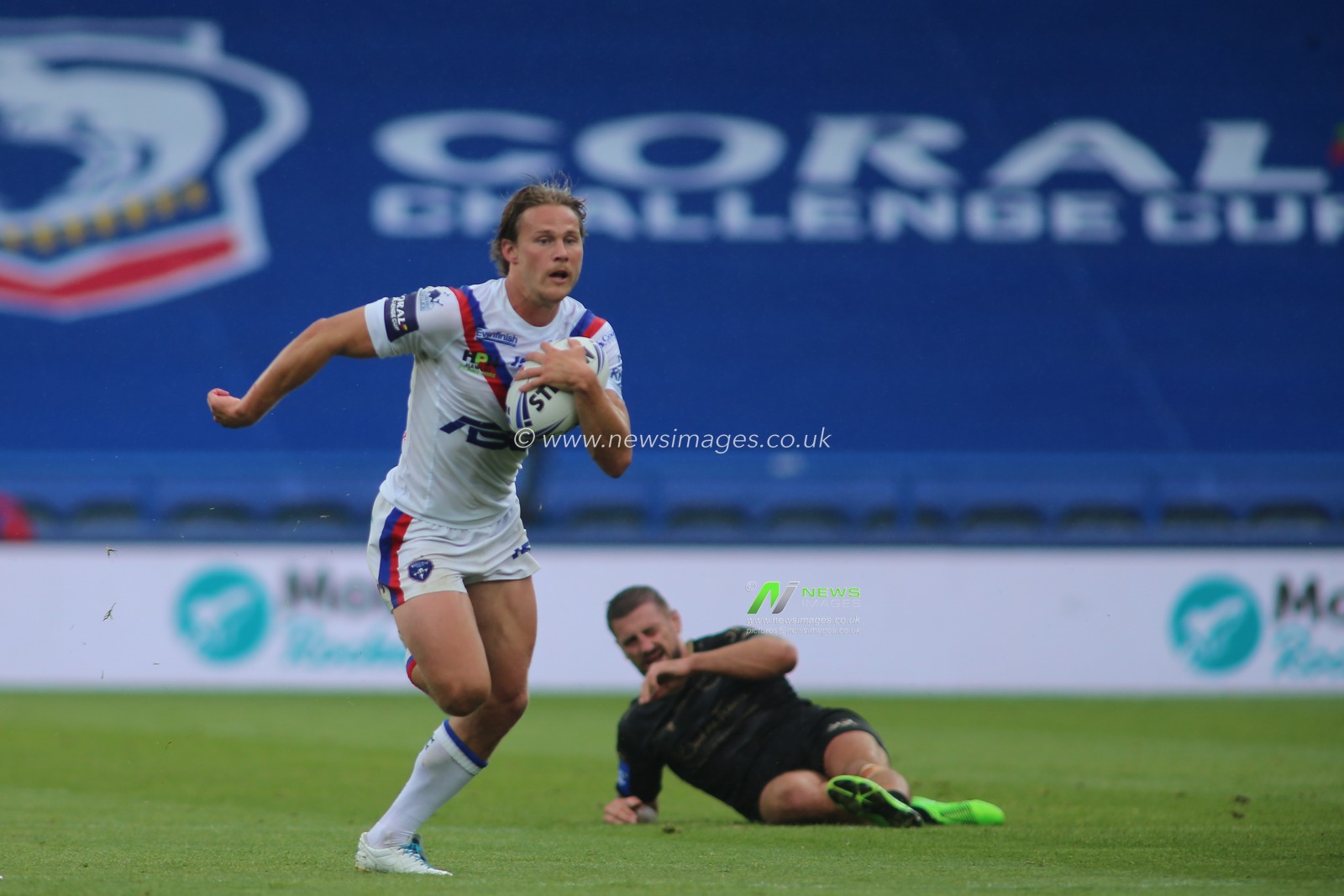 Jacob Miller (6) of Wakefield Trinity makes a break against Catalan Dragon.