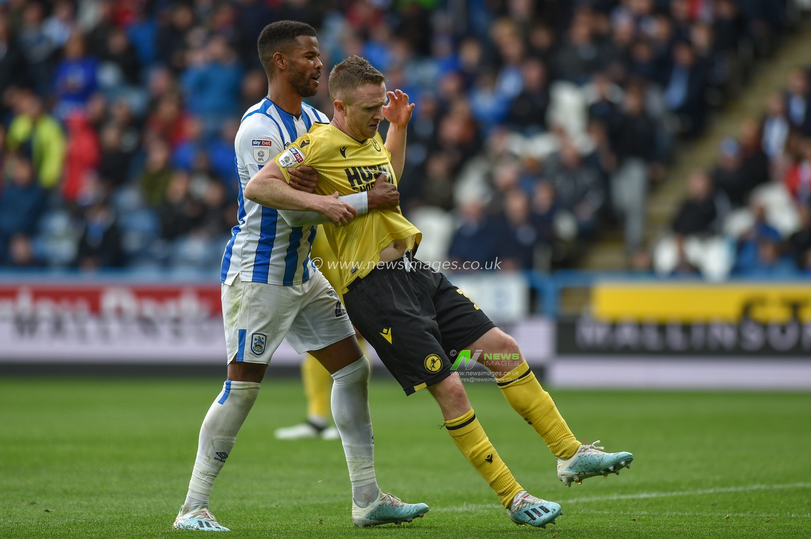 28th September 2019, John Smith's Stadium, Huddersfield, England; Sky Bet Championship, Huddersfield Town v Millwall :Fraizer Cambell (22) of Huddersfield Town assists Shane Ferguson (11) of Millwall off the field after the Millwall player feigns injury getting sent off.

Credit: Dean Williams/News Images
