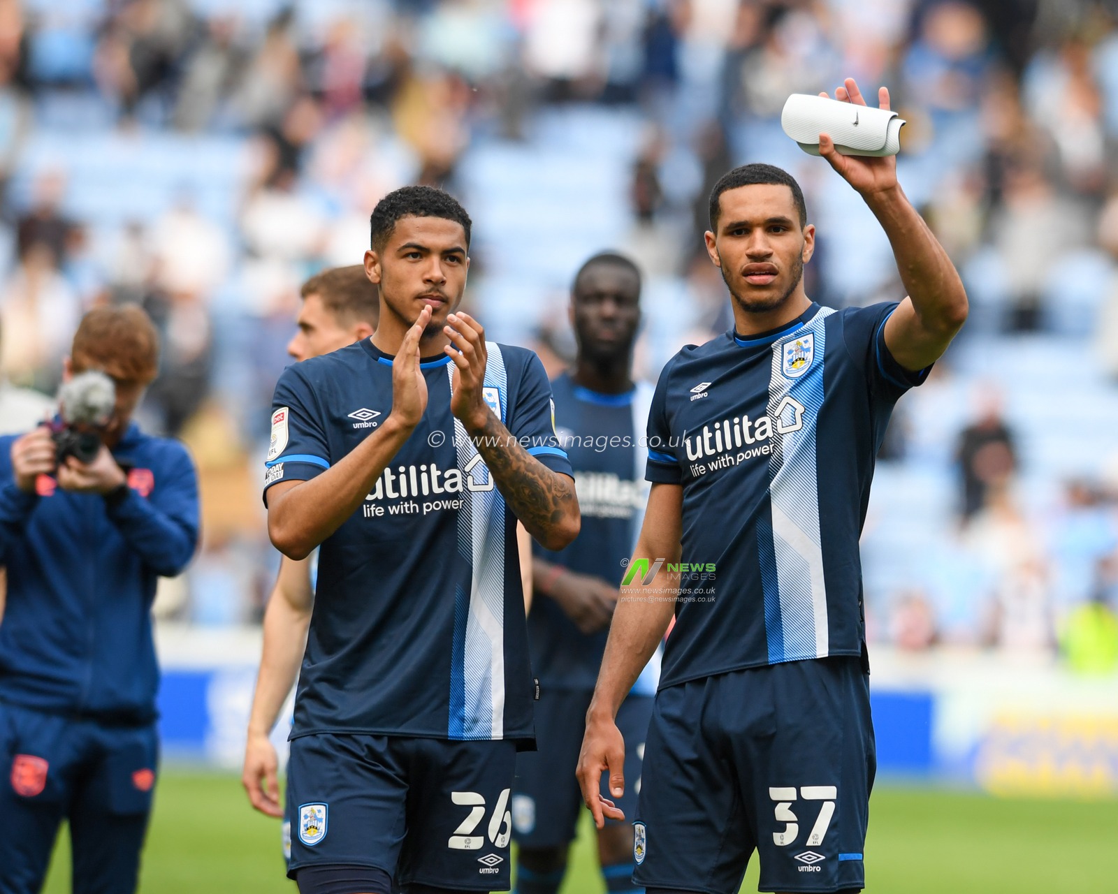 Jon Russell #37 and Levi Colwill #26 of Huddersfield Town thank the travelling supporters after their side beat Coventry City 1-2