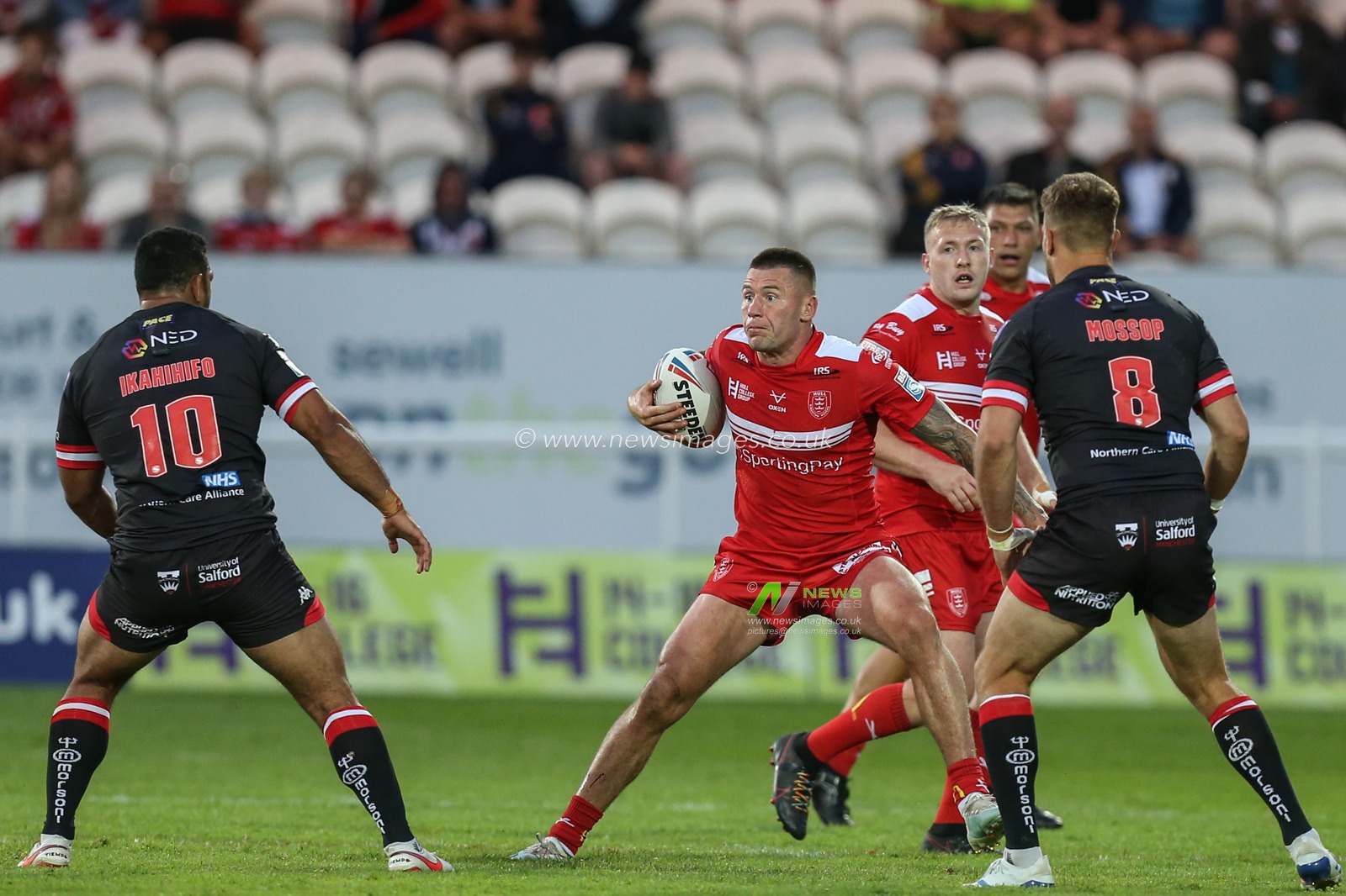 Shaun Kenny-Dowall (4) of Hull KR runs at Sebastine Ikahihifo (10) and Lee Mossop (8) of Salford Red Devils