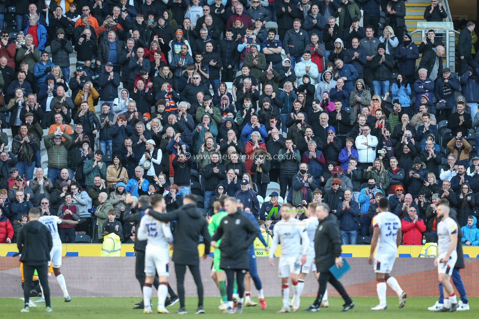 A large following of Luton fans applaud their team at the end of the match