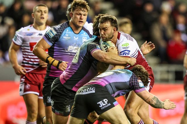 Kaide Ellis of Wigan Warriors is tackled by Harvie Hill of Hull FC and Amir Bourouh of Hull FC during the Betfred Super League match Wigan Warriors vs Hull FC at The Brick Community Stadium, Wigan, United Kingdom on 21 February 2026

(Photo by Alfie Cosgrove/News Images)