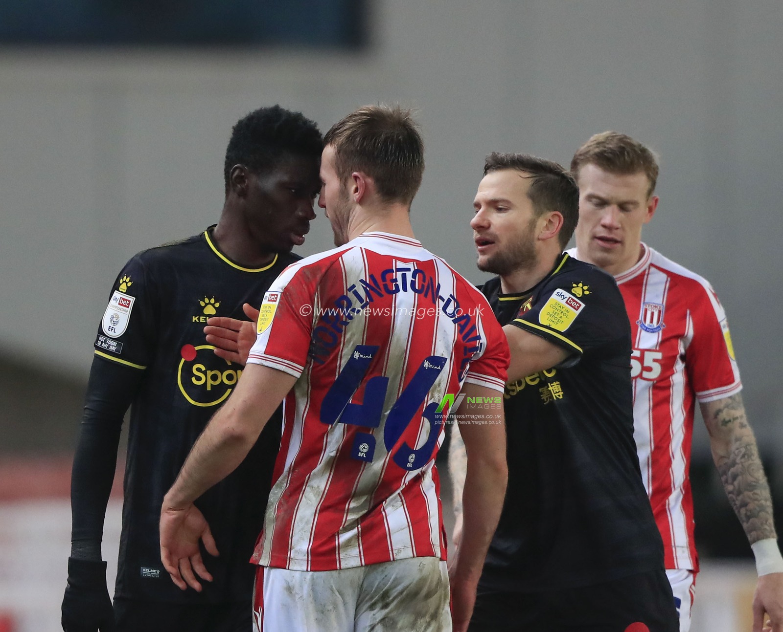 Ismaila Sarr #23 of Watford and Rhys Norrington-Davies #46 of Stoke City confront each other