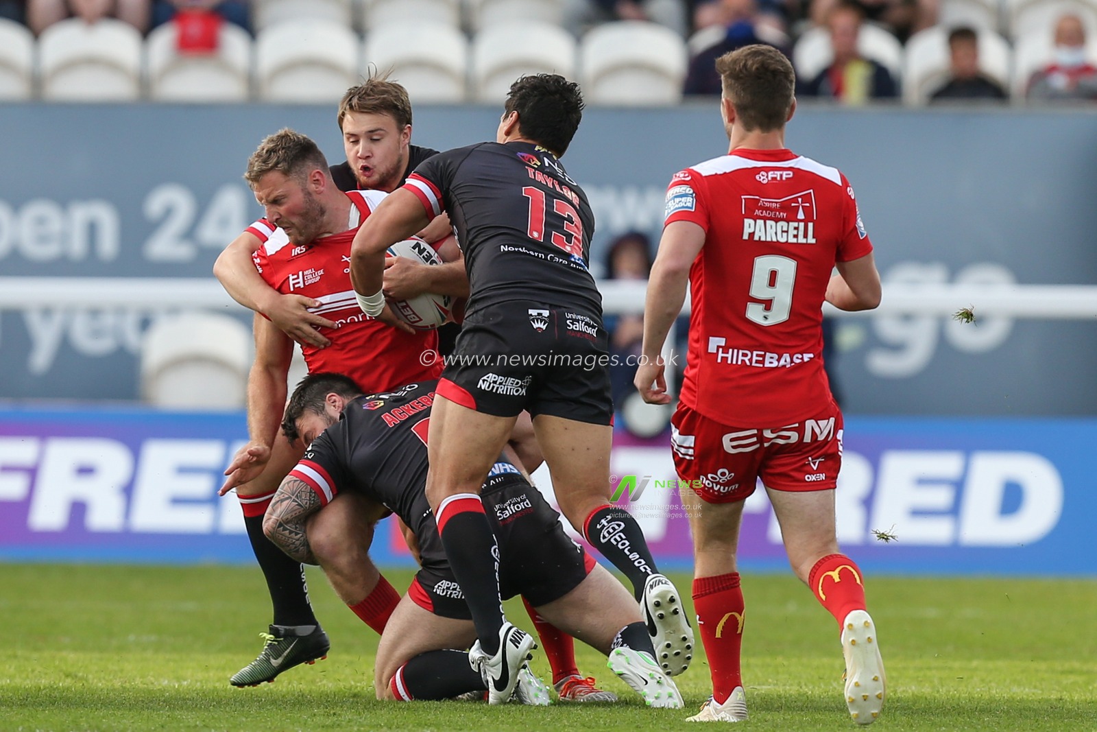 Will Maher (26) of Hull KR is tackled by the Salford defence