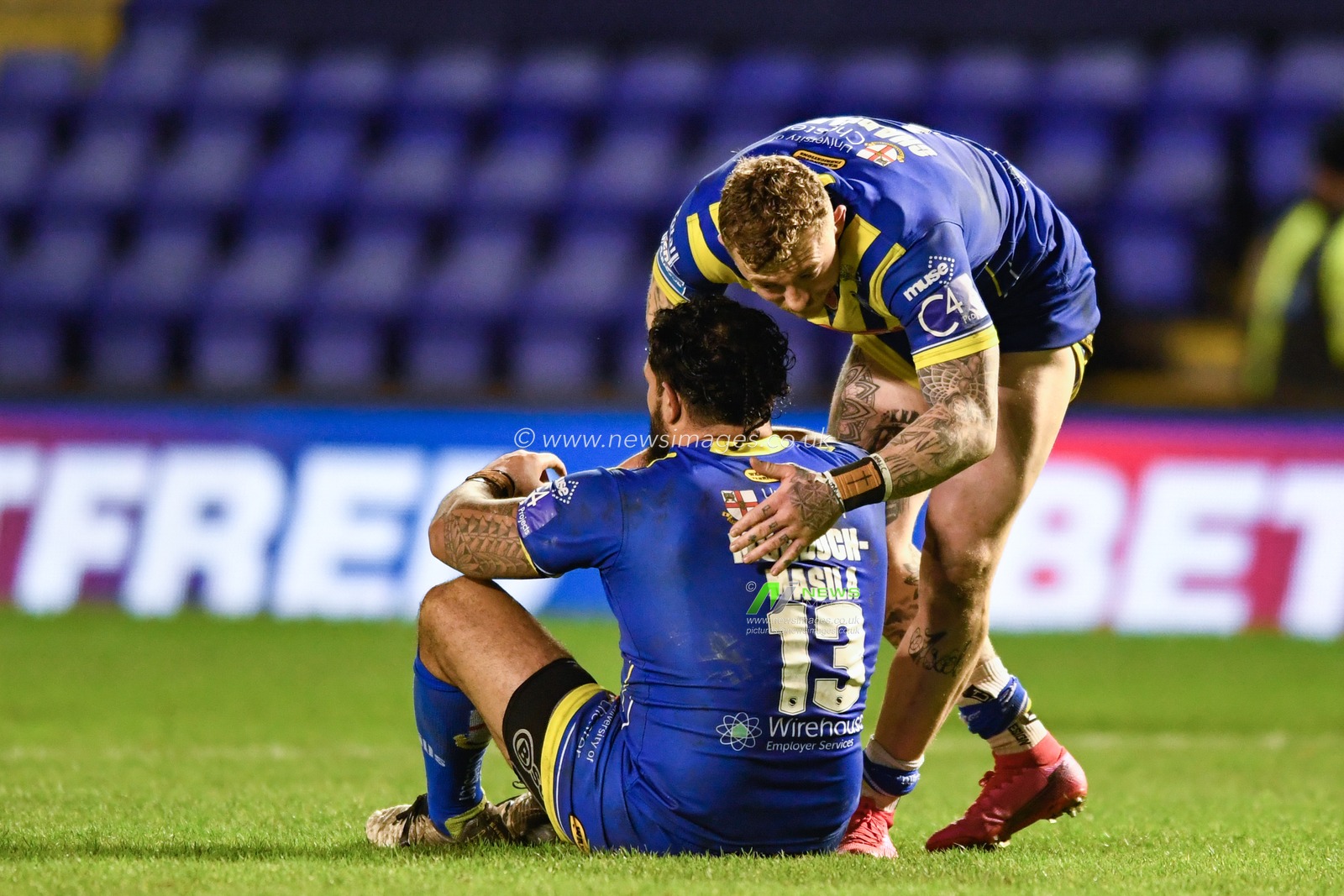 Josh Charnley #5 of Warrington Wolves looks to console Ben Murdoch-Masilla #13 of Warrington Wolves after their team lose at home 14-27