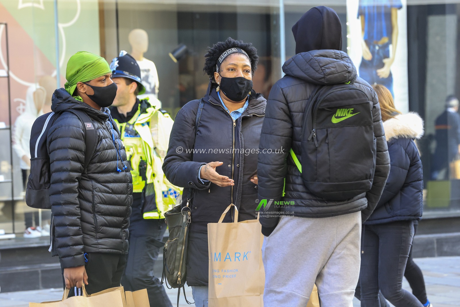 Three people chat after shopping at Primark on Northumberland Street, Newcastle upon Tyne, as shops reopen as national lockdown restrictions are eased