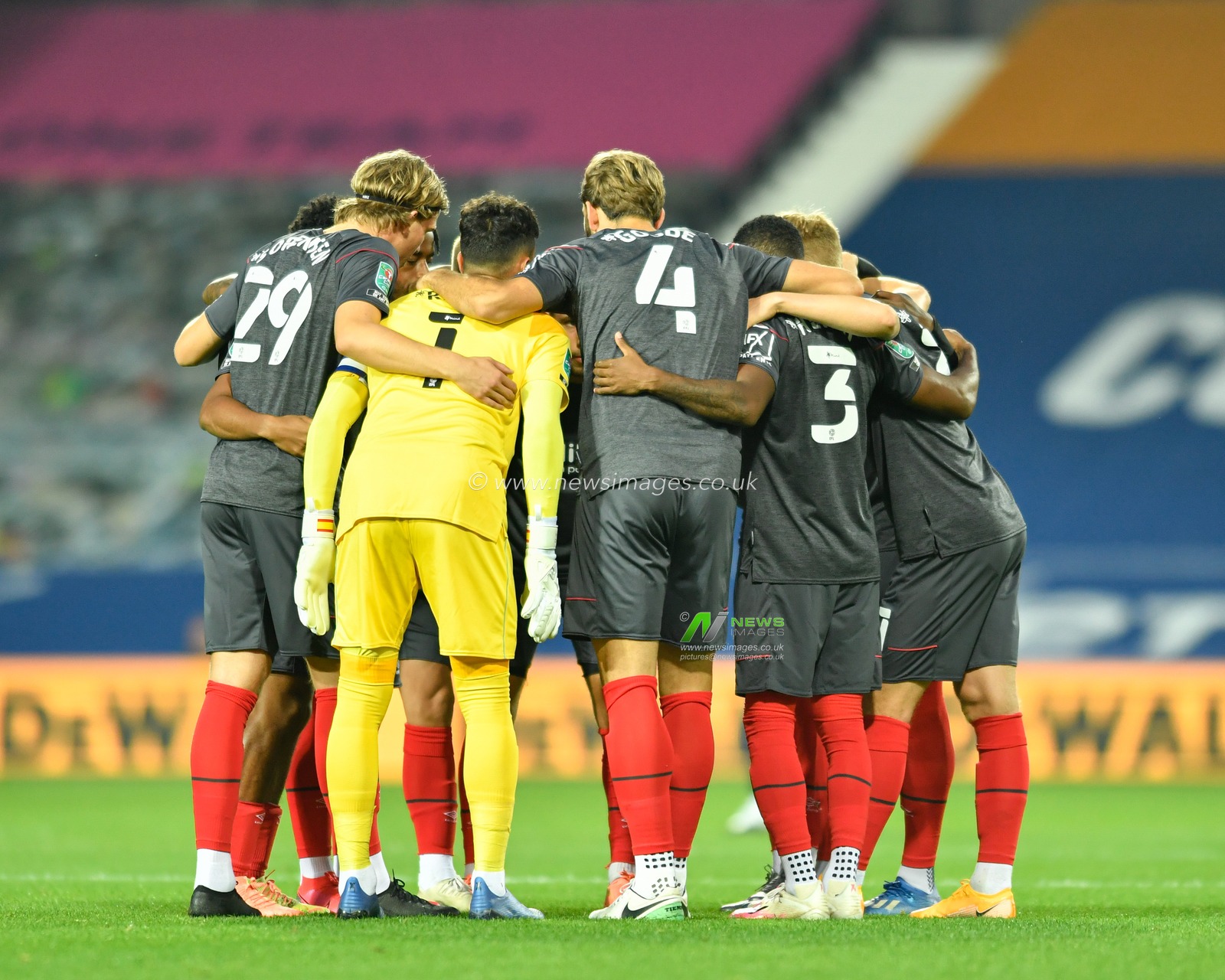 The Brentford team form a huddle before kick off