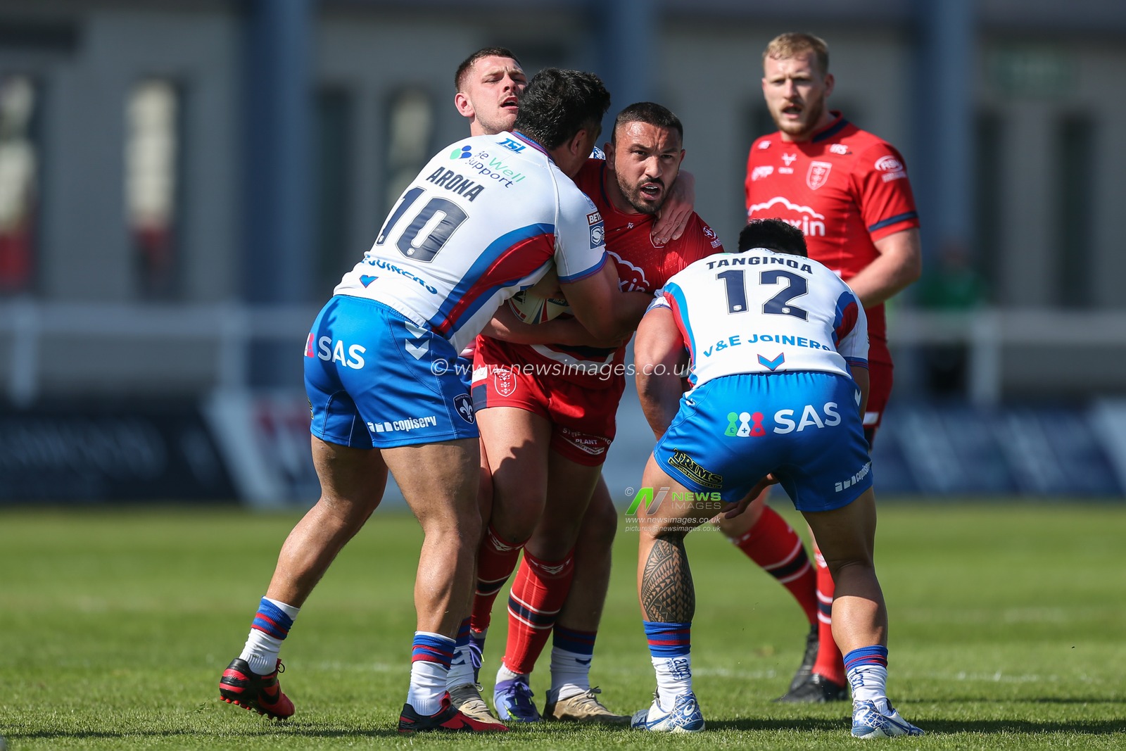 Elliot Minchella #17 of Hull KR is stopped by Tinirau Arona #10 of Wakefield Trinity