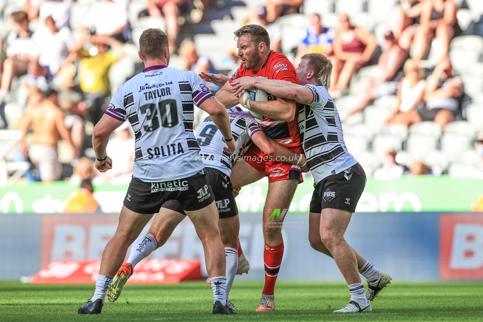 Will Maher #22 of Hull KR is tackled by Danny Houghton #9 of Hull FC
