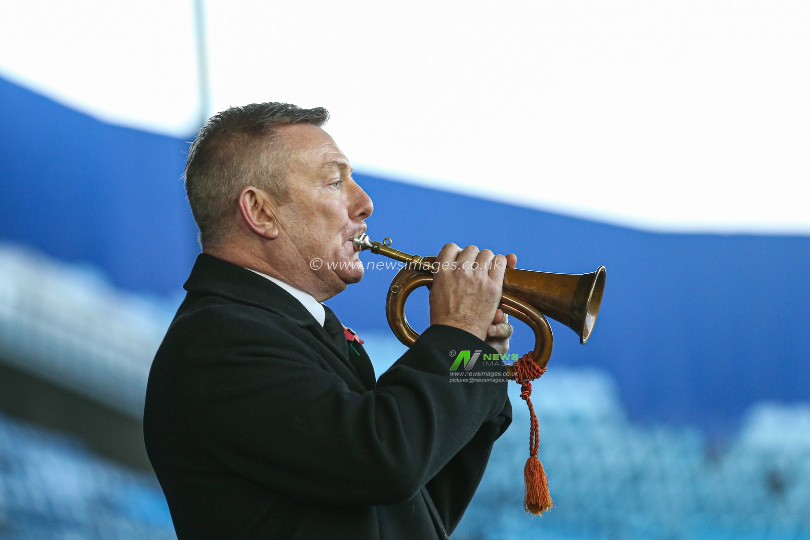 A bugler plays the Last Post as the players observe a minute of silence for Remembrance Sunday before the game