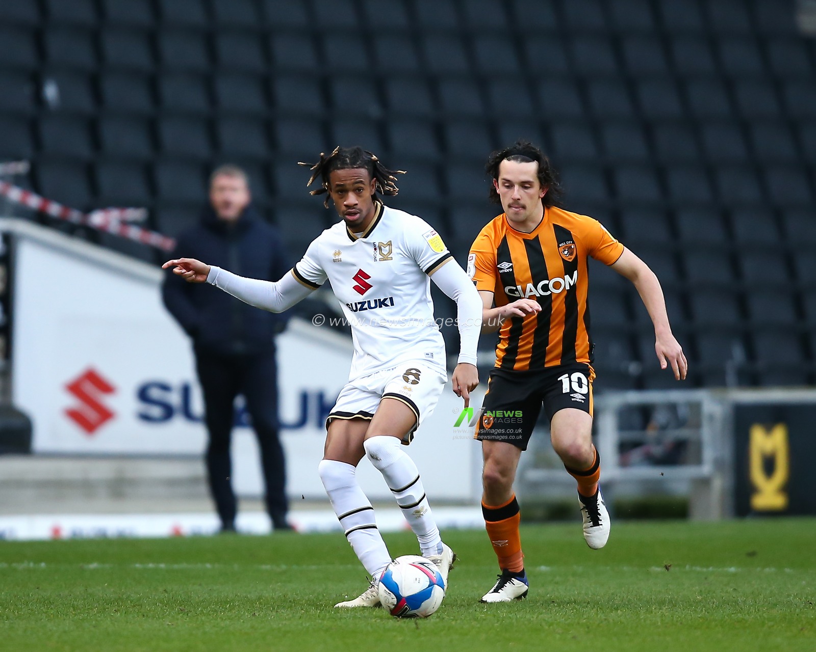 David Kasumu #8 of Milton Keynes Dons passes the ball under pressure from George Honeyman #10 of Hull City