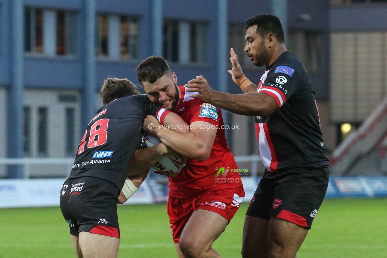 Matty Storton (18) of Hull KR pushes the Salford defence