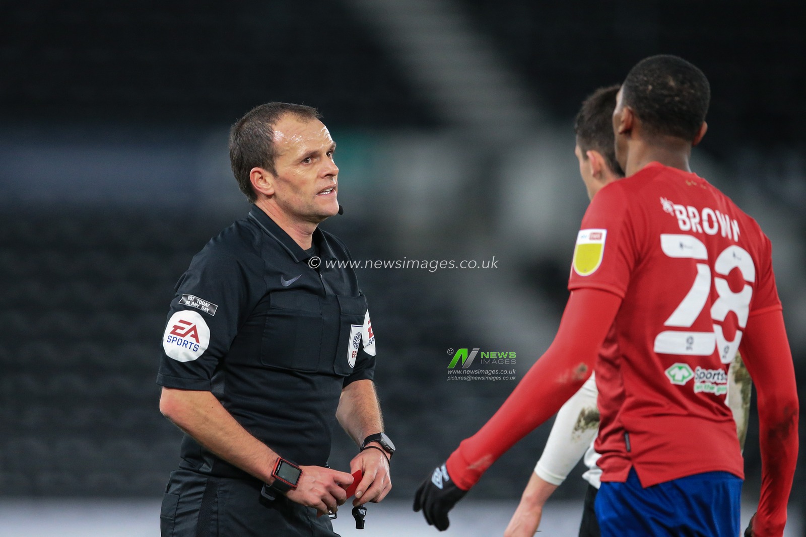 referee Geoff Eltringham gives Jaden Brown #28 of Huddersfield Town a second yellow card followed by a red and sends him off