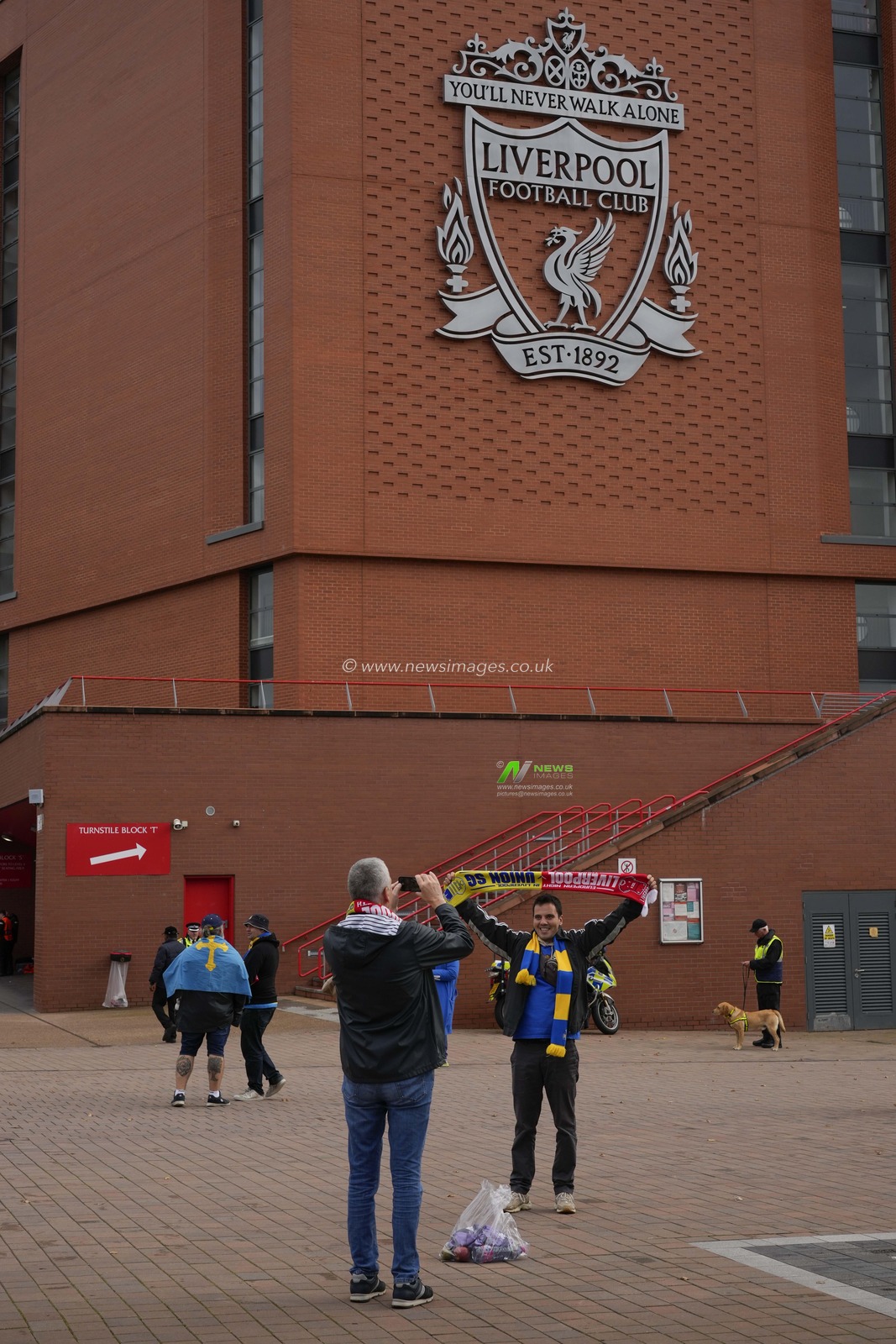 Union Saint-Gilloise fans pose for a photo under the Liverpool crest before the UEFA Europa League match Liverpool vs Union Saint-Gilloise at Anfield, Liverpool, United Kingdom, 5th October 2023

(Photo by Steve Flynn/News Images)