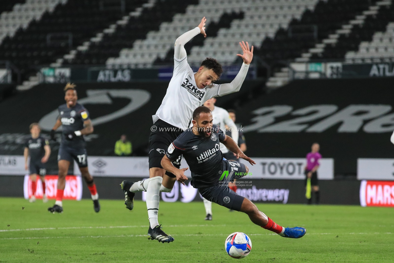 Lee Buchanan #26 of Derby County brings down Bryan Mbeumo #19 of Brentford for a Brentford penalty