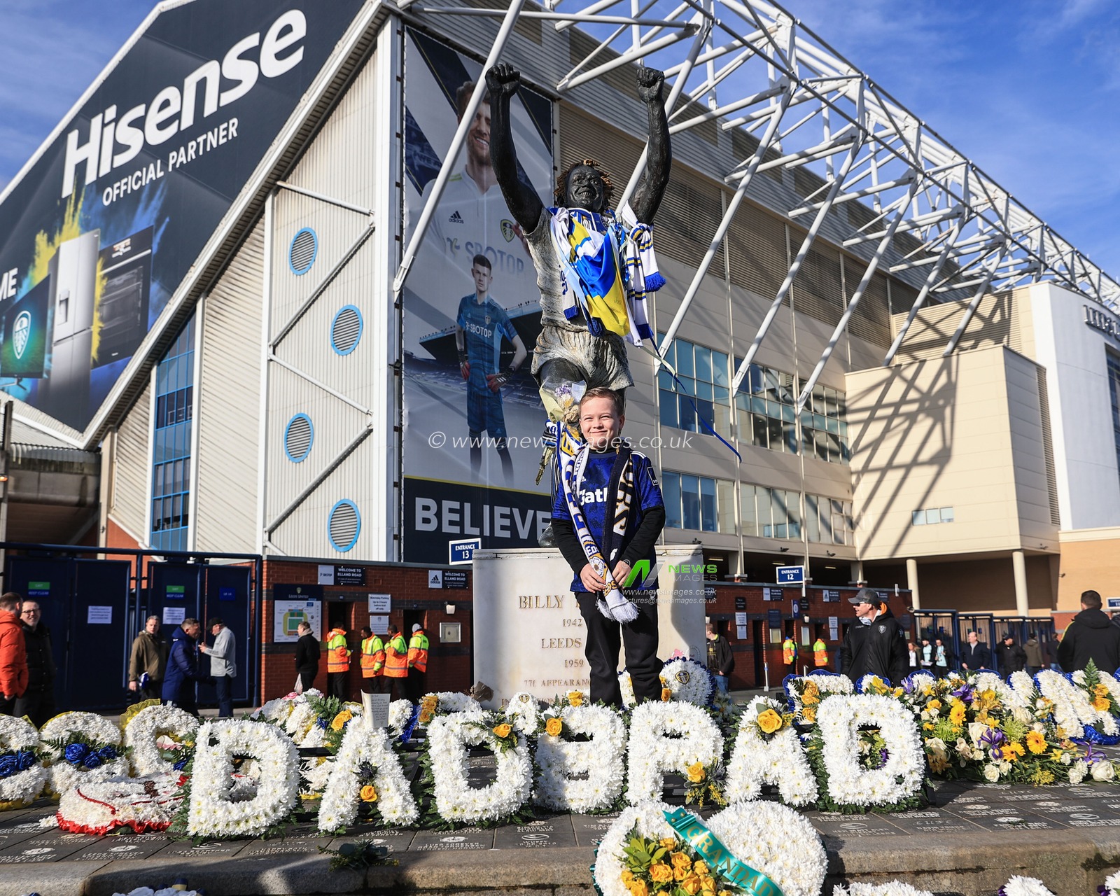 A young fan hashis photo taken at the Billy Bremner statue outside Elland Road
