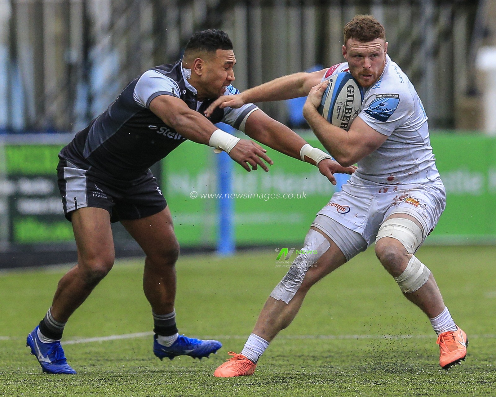 Joe Simmonds of Exeter Chiefs holds off a challenge from Cooper Vuna of Newcastle Falcons
