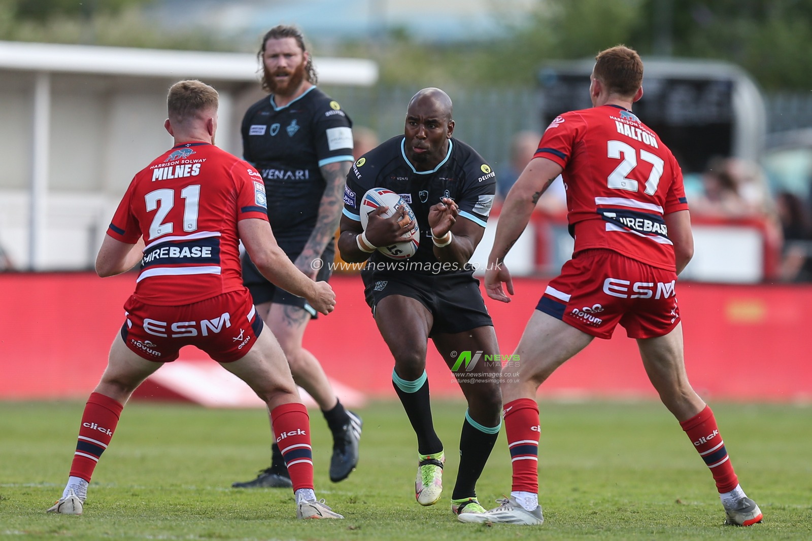 Michael Lawrence #10 of Huddersfield Giants runs at Rowan Milnes #21 of Hull KR