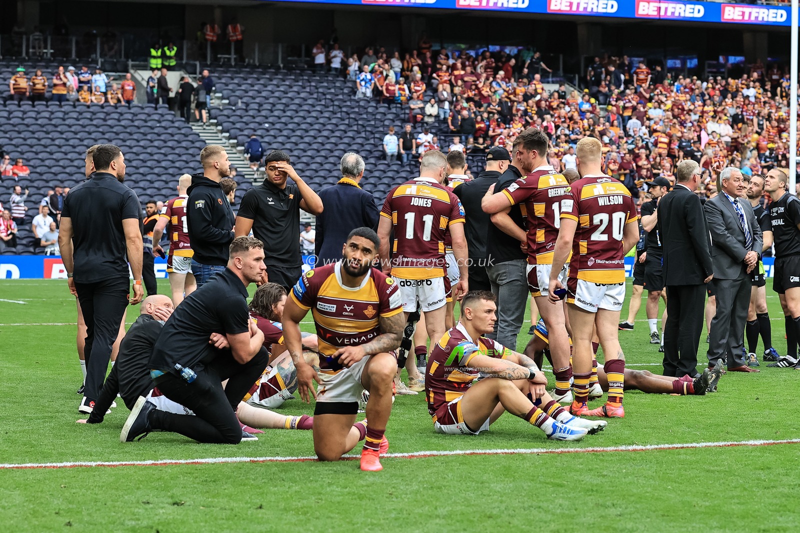 Dejected Huddersfield Giant players watch Wigan lift the cup