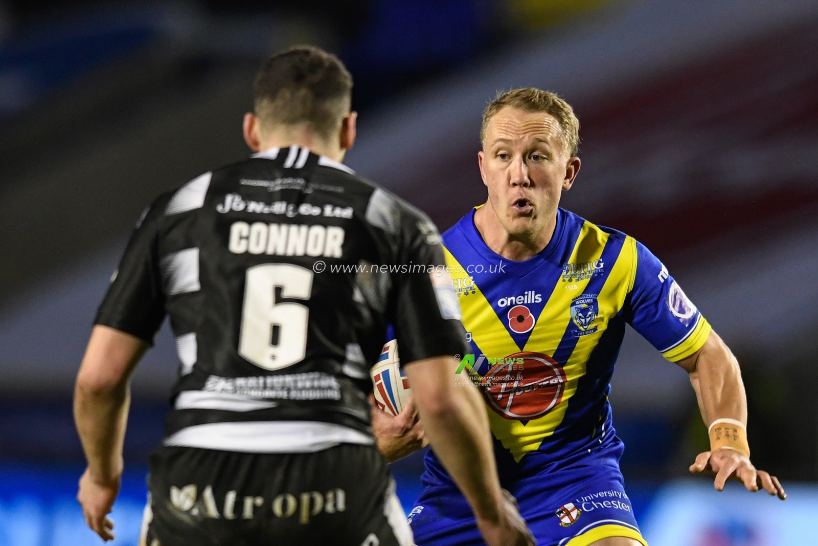 Jason Clark #14 of Warrington Wolves looks for a way past Jake Connor #6 of Hull FC
