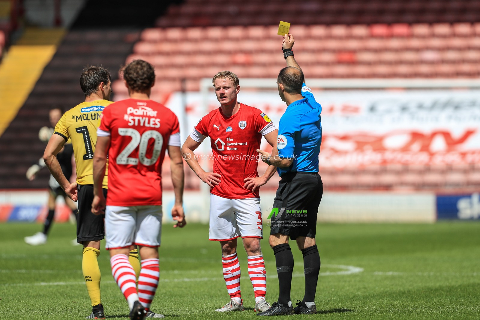 referee Jeremy Simpson gives Ben Williams (3) of Barnsley a yellow card