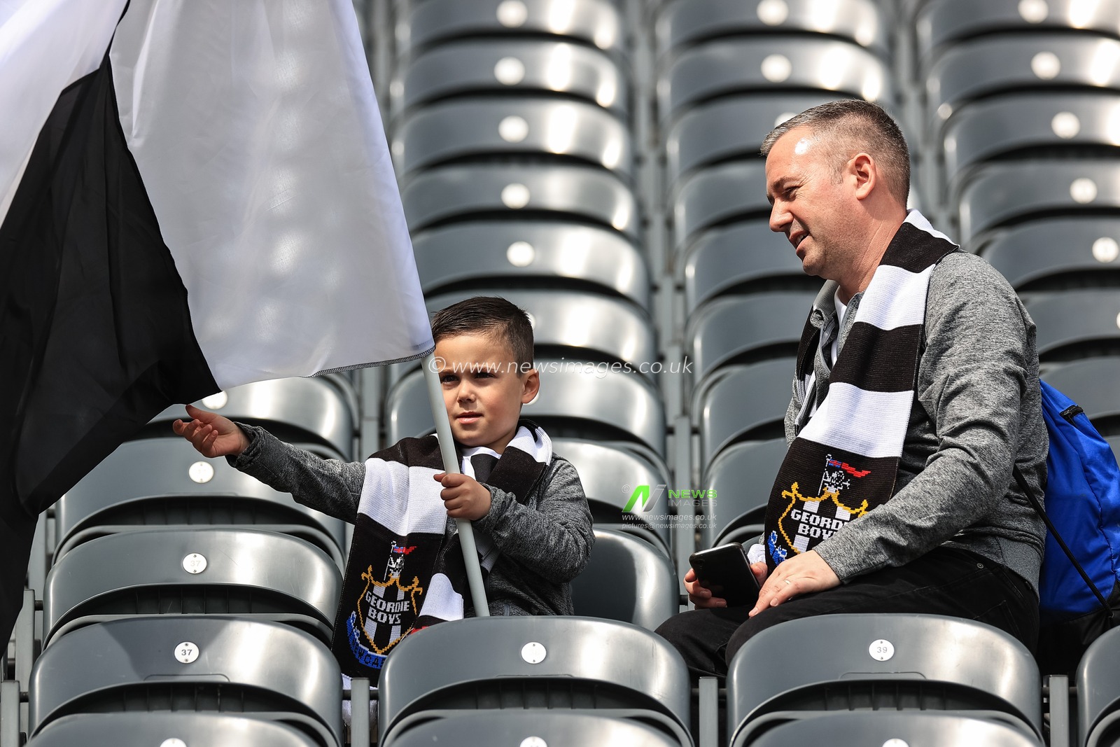 A young Newcastle fan flys a flag
