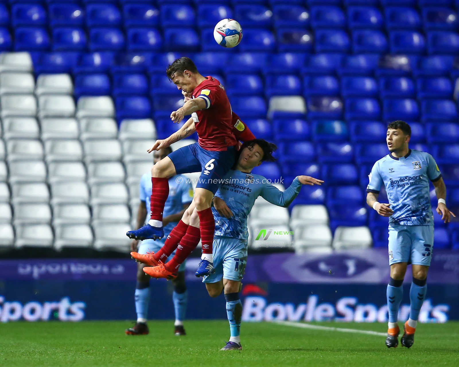 Jonathan Hogg #6 of Huddersfield Town jumps over Callum O'Hare #11 of Coventry City to head the ball