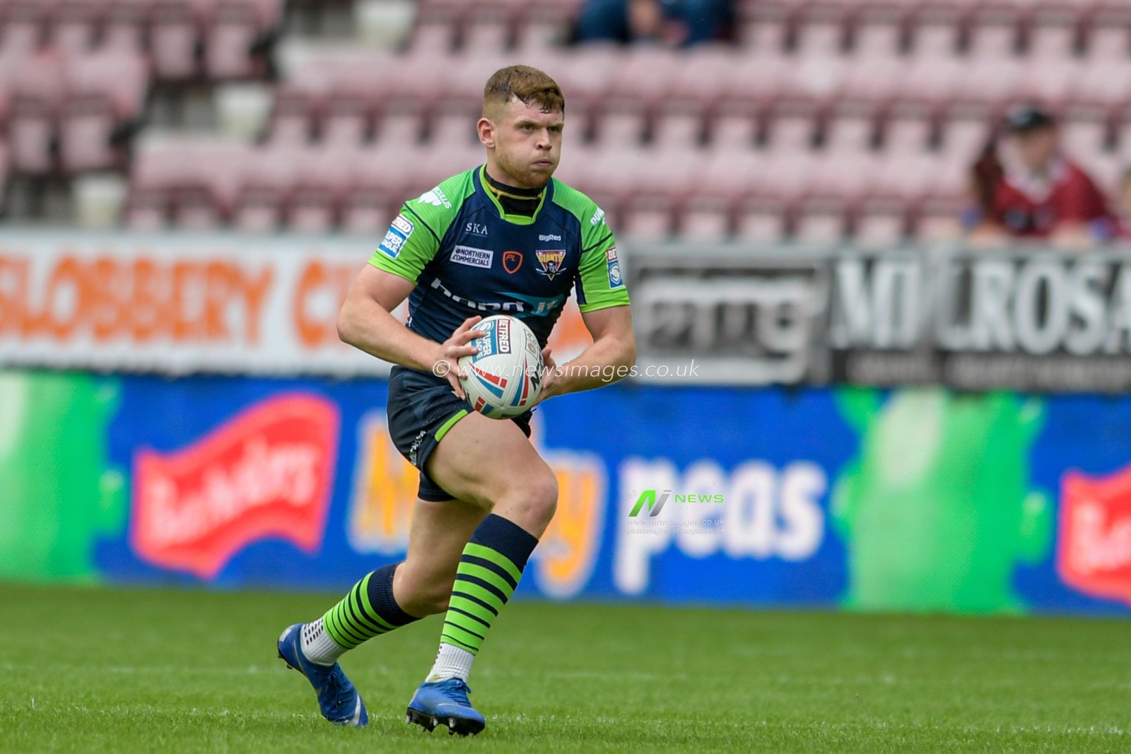 Oliver Russell (23) of Huddersfield Giants runs forward with the ball