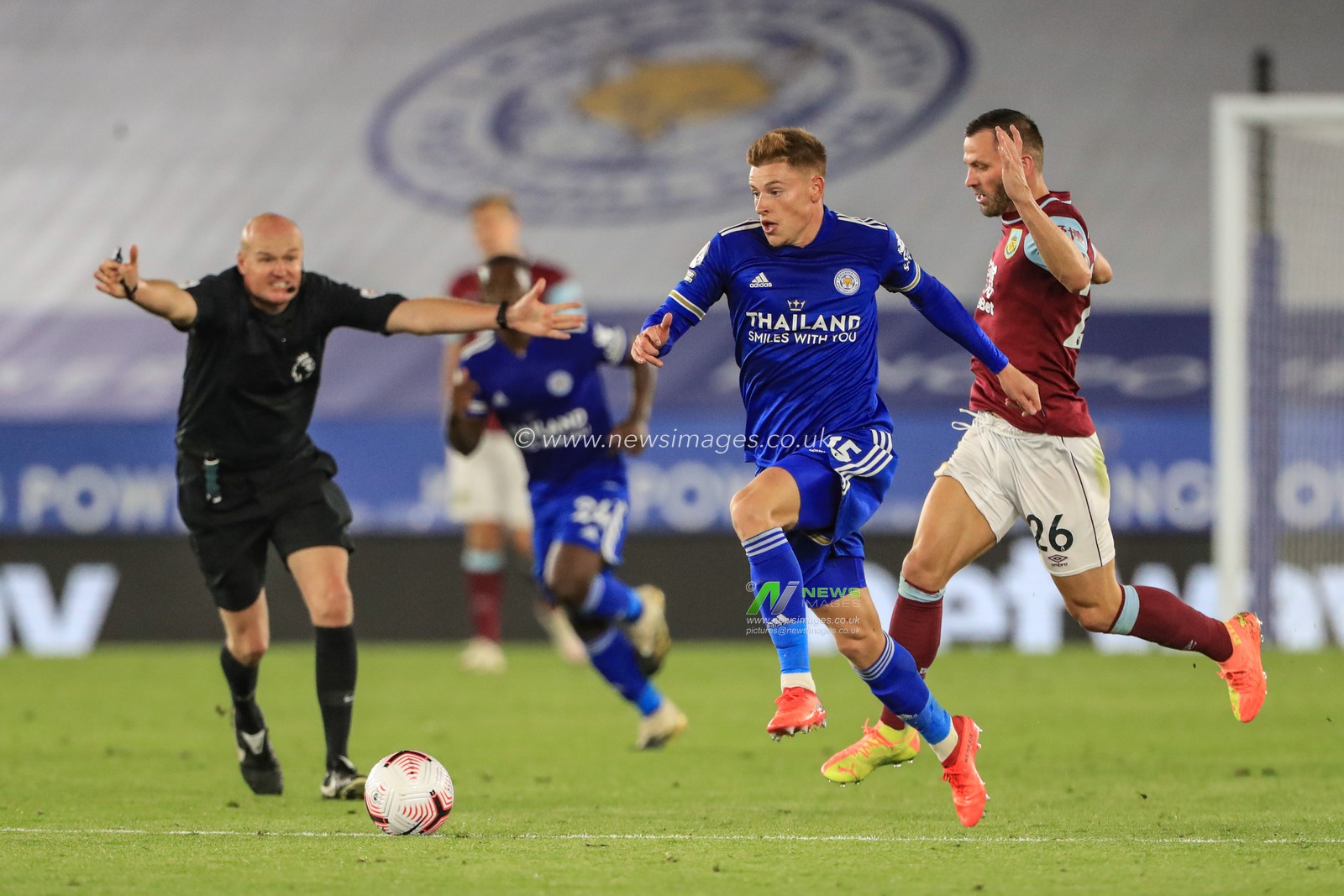 Referee Lee Mason waves play-on as he gives Harvey Barnes (15) of Leicester City the advantage as Phil Bardsley (26) of Burnley tries to hold him back