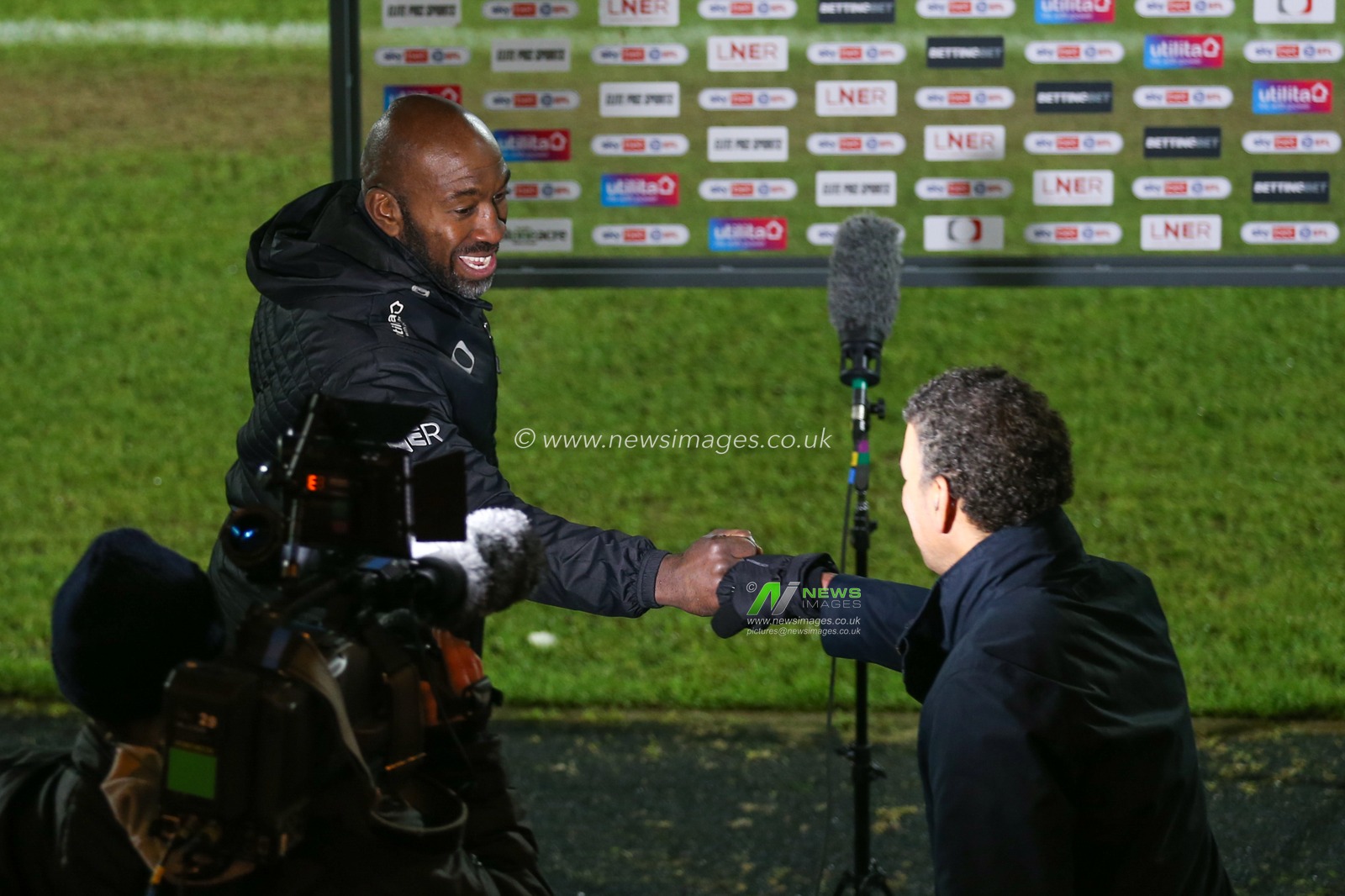 Darren Moore manager of Doncaster Rovers and Sky Sports pundit Chris Kamara bump fists before an interview after the game