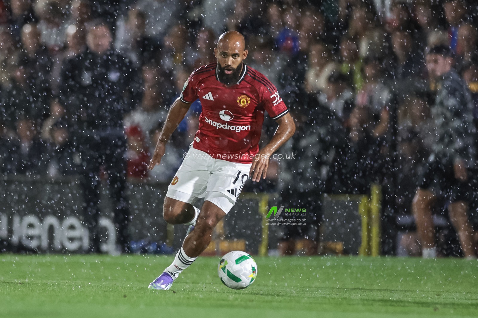 Bryan Mbeumo of Manchester United breaks with the ball in the pouring rain during the Carabao Cup match Grimsby Town vs Manchester United at Blundell Park, Cleethorpes, United Kingdom, 27th August 2025

(Photo by Mark Cosgrove/News Images)